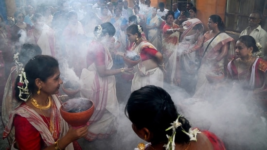 Women perform a traditional Bengali 'dhunuchi' dance ahead of Durga Puja festival at Beniatola Sarbojanin in Kolkata.(PTI)