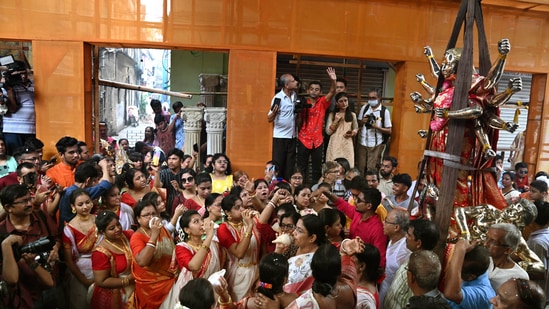 Women in traditional dress play 'conches' on arrival of a Goddess Durga idol weighing one metric ton, at Beniatola Sarbojanin Durga Puja community in Kolkata.(PTI)