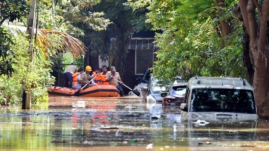Members of a rescue team row their boat past submerged vehicles following torrential rains in Bengaluru, India, September 5, 2022. (REUTERS/Samuel Rajkumar)
