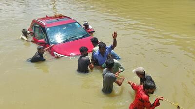 People pull a car through a water-logged road following torrential rains in Bengaluru, India (REUTERS) People pull a car through a water-logged road following torrential rains in Bengaluru, India (REUTERS)
