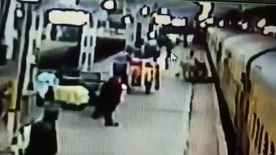 The image, taken from the video, shows an RPF cop saving a passenger's life after he slipped while de-boarding a moving train. (Twitter/@RailMinIndia)