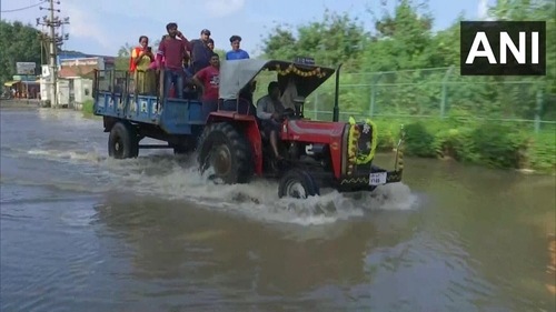 IT employees commute to their workplaces on a tractor amid waterlogging after heavy rain. (ANI) IT employees commute to their workplaces on a tractor amid waterlogging after heavy rain. (ANI)