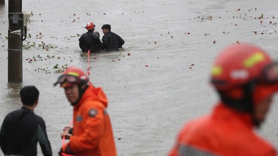 Corée du Sud Super Typhon Hinnamnor : Des secouristes sud-coréens sauvent un homme dans un parc inondé au bord de la rivière (AFP).
