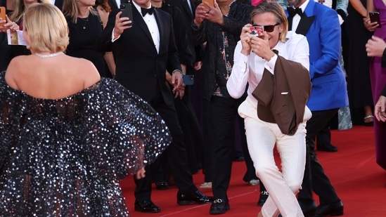 Chris Pine, right, takes a picture of Florence Pugh upon arrival at the premiere of the film Don't Worry Darling during the 79th edition of the Venice Film Festival in Venice.(Joel C Ryan/Invision/AP)