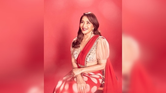 Madhuri Dixit's saree is from the collection of designer Anju Modi's creations. She matched it with a puffed sleeves blouse featuring a plunging neckline.(Instagram/@madhuridixitnene)