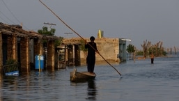 Inundações no Paquistão: Um homem rema seu barco enquanto passa por um mercado inundado no Paquistão. 