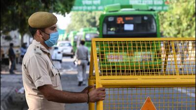 New Delhi, India - May 7, 2020: A Delhi Police personnel keeps guard as a bus with migrant workers crosses a barricade towards New Delhi Railway Station to board the first ‘Shramik Express’ train to their native state, in New Delhi, India, on Thursday, May 7, 2020. (Photo by Biplov Bhuyan/ Hindustan Times) (Biplov Bhuyan/HT PHOTO) New Delhi, India - May 7, 2020: A Delhi Police personnel keeps guard as a bus with migrant workers crosses a barricade towards New Delhi Railway Station to board the first ‘Shramik Express’ train to their native state, in New Delhi, India, on Thursday, May 7, 2020. (Photo by Biplov Bhuyan/ Hindustan Times) (Biplov Bhuyan/HT PHOTO)