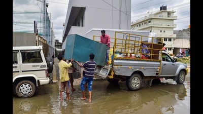 Residents carrying their belongings shift from a flooded locality of Bellandur after heavy monsoon rains, in Bengaluru. (PTI) Residents carrying their belongings shift from a flooded locality of Bellandur after heavy monsoon rains, in Bengaluru. (PTI)