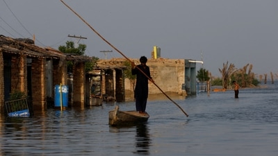 Pakistan Floods: A man rows his boat as he passes through flooded market in Pakistan.&nbsp; (Reuters)
