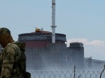 Russia-Ukraine War: A serviceman with a Russian flag on his uniform stands guard near the Zaporizhzhia Nuclear Power Plant.