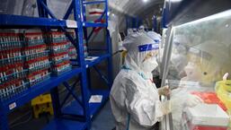 Staff at the Sichuan Provincial People's Hospital test nucleic acid samples in a mobile laboratory set up at a sports center after the Covid-19 outbreak in Chengdu, Sichuan province, China.  (Reuters)