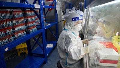 Staff members of Sichuan Provincial People's Hospital test nucleic acid samples inside a mobile laboratory set up at a sports centre, following the coronavirus disease (Covid-19) outbreak in Chengdu, Sichuan province, China (Photo via REUTERS ATTENTION EDITORS)