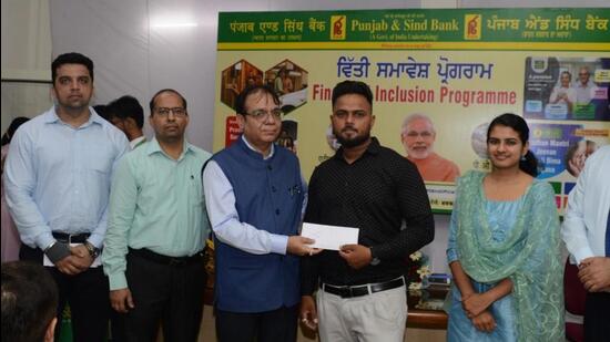 Punjab and Sind Bank officials handing over a credit sanction letter to a beneficiary in Ludhiana. (HT PHOTO)