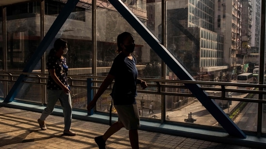 Hong Kong Coronavirus: People cross a footbridge in Hong Kong.(AFP)