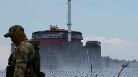 Russia-Ukraine War: A serviceman with a Russian flag on his uniform stands guard near the Zaporizhzhia Nuclear Power Plant.(Reuters)