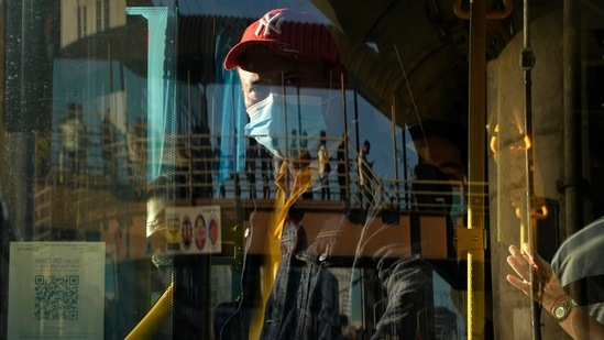 Coronavirus: A bus attendant waits for passengers at a bus stop in Manila, Philippines.(AP)