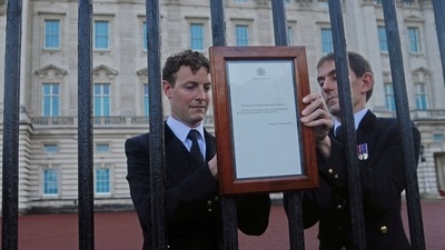 Queen Elizabeth II Passes Away: Members of royal household staff post a notice on the gates of the Buckingham Palace. (Reuters)