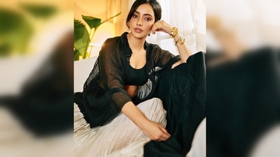 Neha Sharma wore a black cropped tank top paired with a pleated white flowy skirt and a sheer black cape. (Instagram/@nehasharmaofficial) Neha Sharma wore a black cropped tank top paired with a pleated white flowy skirt and a sheer black cape. (Instagram/@nehasharmaofficial)
