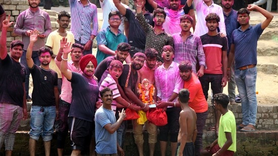 Devotees assemble near the Sirhind canal to witness Ganpati Visarjan in Bathinda, Punjab.