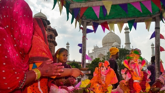 Devotees at a Ganapati Visarjan procession in the backdrop of Taj Mahal, in Agra, Wednesday.(PTI)