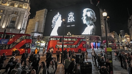 A big screen displays photos of Queen Elizabeth II at Piccadilly Circus in London, Friday, September 9, 2022. (AP Photo/Martin Meissner)