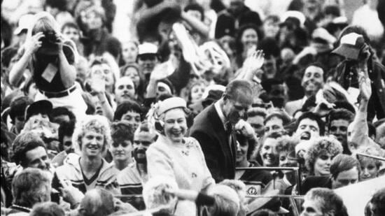 In this Oct. 9, 1982 file photo, Britain's Queen Elizabeth II, centre and her husband Prince Philip react, as they drive through the crowd of athletes and officials during the Closing Ceremony of the 12th Commonwealth Games, in the Queen Elizabeth II Jubilee Sports Centre, in Brisbane, Australia. (AP)