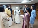 The image shows the saree-clad robot receiving loan documents from bank employees.