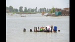 Three flood victims float their belongings on an upturned table, Jafferabad District, Pakistan, September 5, 2022 (REUTERS) Three flood victims float their belongings on an upturned table, Jafferabad District, Pakistan, September 5, 2022 (REUTERS)