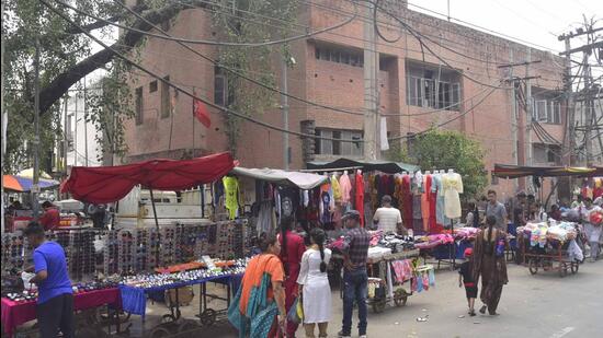 Street vendors encroachments on road portion outside the Pink Plaza Market at Chhaura Baazar in Ludhiana. One of the MC officials, requesting anonymity, said earlier, a few shopkeepers also used to charge rent from vendors for installing vends outside the market. Due to some tussle between both the parties over payment of rent, shopkeepers now want vends to be removed from the market, the official said (Gurpreet Singh/HT)