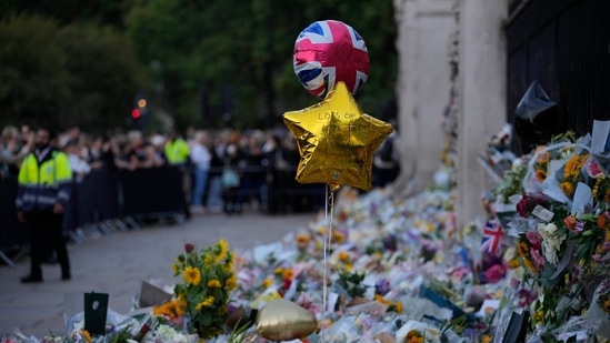 Queen Elizabeth II death: Flowers and balloons for Queen Elizabeth II are placed at the gates outside Buckingham Palace, in London.(AP)