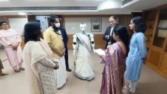 The image shows the saree-clad robot receiving loan documents from bank employees.(Twitter/@Ananth_IRAS)