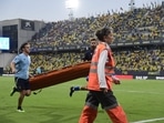 Players and emergency service members run holding a stretcher during a play interruption as a supporter fainted in the tribunes. Players and emergency service members run holding a stretcher during a play interruption as a supporter fainted in the tribunes.