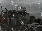 A building damaged by a Russian missile strike is reflected in a window broken with shrapnel, amid Russia's attack on Ukraine in central Dnipro, on Sunday.&nbsp;