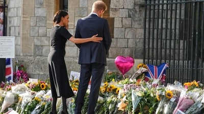 Meghan Markle, Duchess of Sussex, holds Prince Harry, Duke of Sussex, as he views the hundreds of tributes for the late Queen Elizabeth II.&nbsp; (AP)