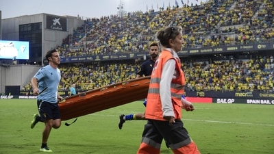 Players and emergency service members run holding a stretcher during a play interruption as a supporter fainted in the tribunes. (AFP) Players and emergency service members run holding a stretcher during a play interruption as a supporter fainted in the tribunes. (AFP)