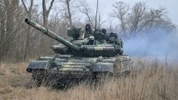 Service members of the Ukrainian armed forces are seen atop of a tank.