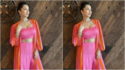 Sunny, for Hyderabad promotions, decked up in a silk slip pink cropped top and teamed it with a pair of pink silk palazzos with wide legs. She added more drama to her look with a silk pink and orange oversized shrug featuring stripes in silver resham threads and puffy full sleeves. (Instagram/@sunnyleone)