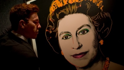 Bonhams employee George Foren poses for photographs with a rare trial proof copy of Andy Warhol's 1985 portrait of Britain's Queen Elizabeth II, at the auction house's offices in central London, July 9, 2012. (AP)
