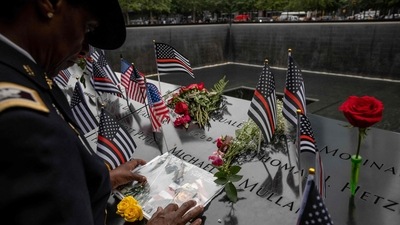 Colonel Davis touches a photorgaph of her colleague, Captain Micheal Dermott Mullan, at the 9/11 Memorial in New York City. (AFP) Colonel Davis touches a photorgaph of her colleague, Captain Micheal Dermott Mullan, at the 9/11 Memorial in New York City. (AFP)