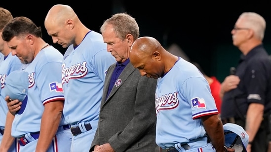 Former President George W. Bush, second from front right, stands with Texas Rangers interim manager Tony Beasley, front right, and others for a moment of silence for 9/11 before a baseball game. (AP)