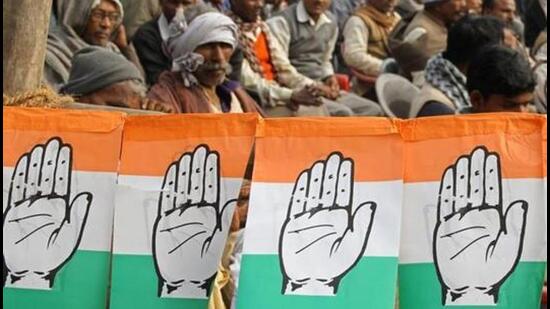 Congress party workers sit next to flags of party's logo. (Reuters)