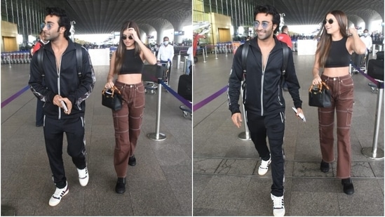 Aadar wore a black zipped jumper and track pants to the airport. He styled them with white lace-up sneakers, tinted sunglasses, and a messy hairdo.(HT Photo/Varinder Chawla)