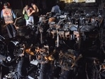 Police officials stand amidst damaged scooters after a fire broke out at an electric scooter showroom in the southern city of Secunderabad, India.