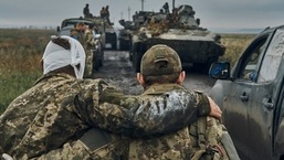 Guerra Rússia-Ucrânia: Um soldado ucraniano ajuda um soldado ferido na estrada no território libertado na região de Kharkiv, na Ucrânia.