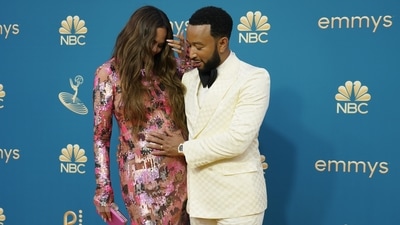 Model Chrissy Teigen made heads turn at the Emmys 2022 red carpet by flaunting her baby bump in style alongside husband John Legend. She donned a long-sleeve patchwork gown with sequins. She elevated her stylish look with a hot pink clutch. On the other hand, John appeared in an all-white outfit. (AP) Model Chrissy Teigen made heads turn at the Emmys 2022 red carpet by flaunting her baby bump in style alongside husband John Legend. She donned a long-sleeve patchwork gown with sequins. She elevated her stylish look with a hot pink clutch. On the other hand, John appeared in an all-white outfit. (AP)