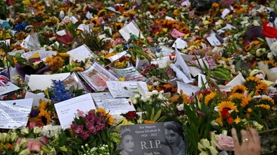 Queen Elizabeth II Funeral: Members of the public look at flowers and tributes left in Green Park in London. (AFP) Queen Elizabeth II Funeral: Members of the public look at flowers and tributes left in Green Park in London. (AFP)