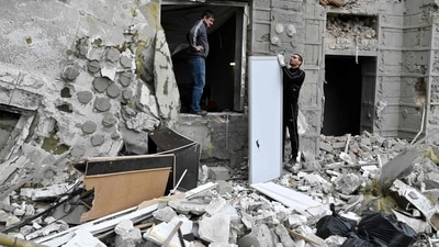 Russia-Ukraine War: &nbsp;Local residents stand outside their building partially destroyed by a missile strike on Kharkiv. (AFP)