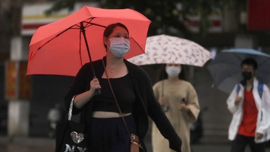 Typhoon Muifa In China: People walk in the rain, ahead of the approaching Typhoon Muifa.(AP)