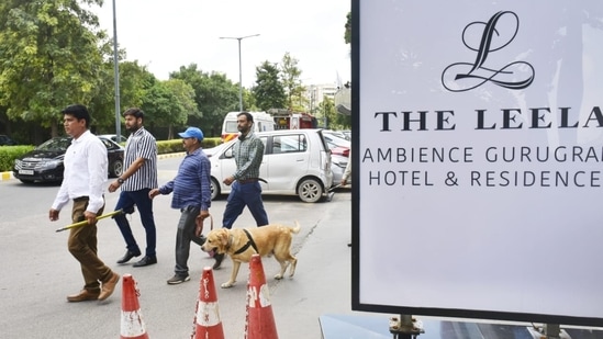 Staff and the guests of The Leela Ambience hotel stood outside as the bomb squad searched the premises.(HT Photo/Vipin Kumar)