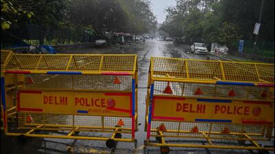 TOPSHOT - A Delhi police barrier blocks a street during a Delhi state-wide weekend curfew imposed by the authorities to curb the spreading of the Covid-19 coronavirus in New Delhi on January 8, 2022. (Photo by Prakash SINGH / AFP) (AFP)